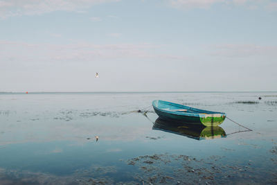 Boat moored on sea against sky