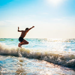 Man surfing in sea against sky