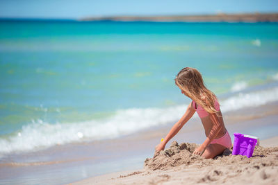 Rear view of woman standing at beach