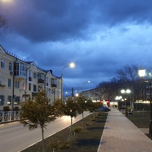 Street amidst buildings against sky at dusk