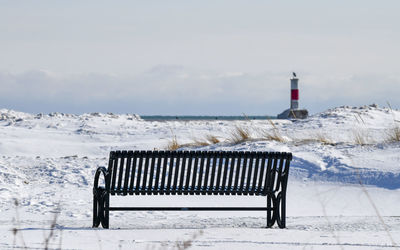 Lighthouse by sea against sky during winter