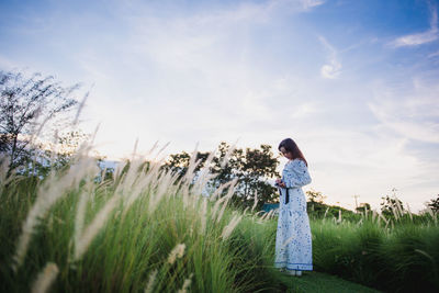 Woman standing on field against sky