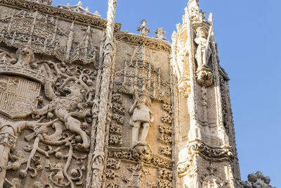 Low angle view of statues on building against sky