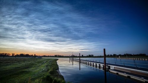 Bridge over river against sky during sunset