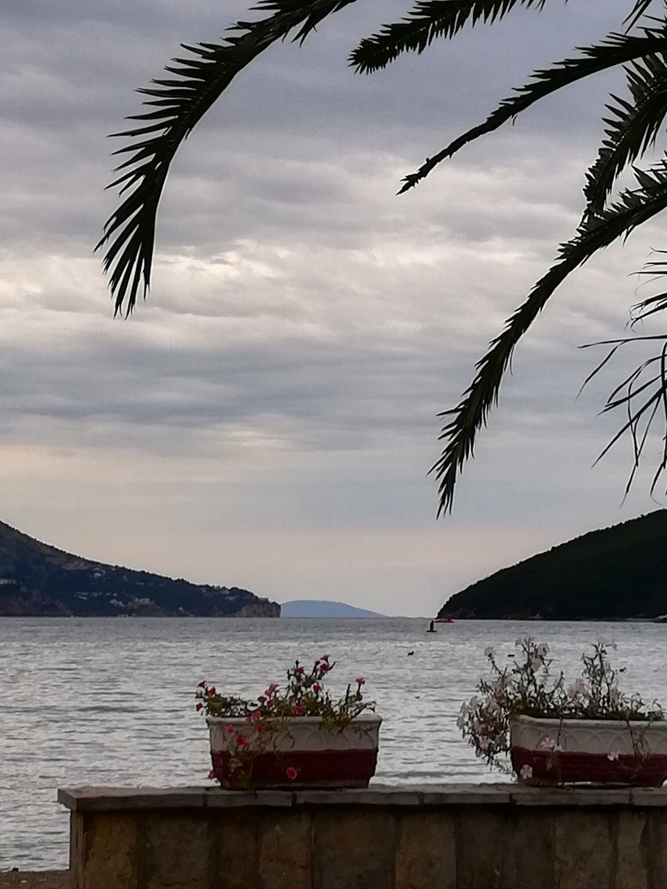 SCENIC VIEW OF SEA BY MOUNTAIN AGAINST SKY