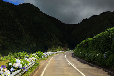 Sunlight falling on empty road against mountains at azores