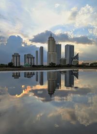 Reflection of buildings in city against sky