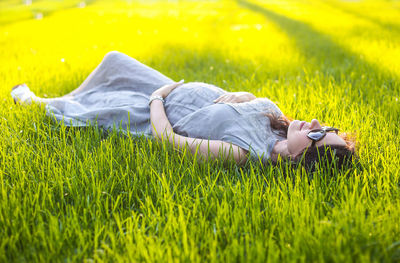Woman lying on grassy field