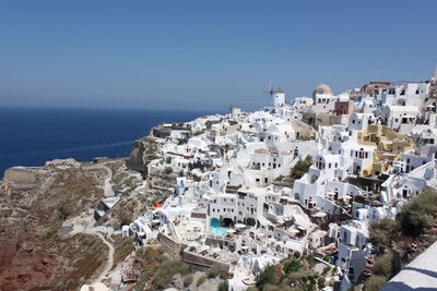 High angle view of townscape by sea against clear sky