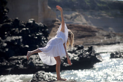 Rear view of woman dancing at beach