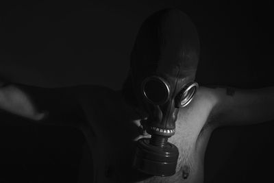 Man wearing gas mask in darkroom