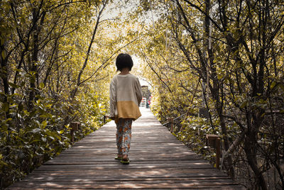 Rear view of woman walking on footpath