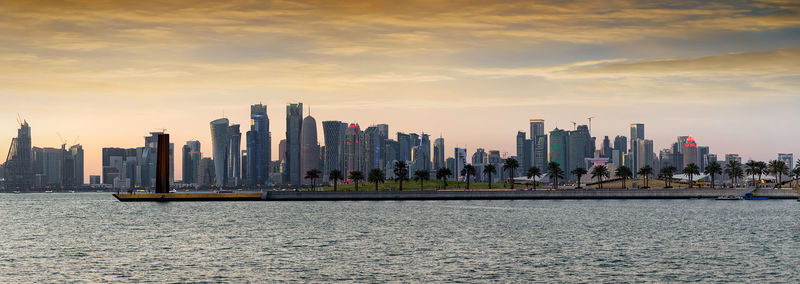 Panoramic view of buildings and sea in city during sunset