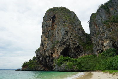 Rock formations by sea against sky