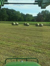 Hay bales on field against sky