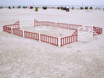 North sea beach with a small fenced beach ball field and view over the wadden sea to the horizon.