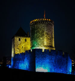 Low angle view of illuminated building against sky at night