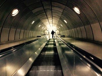 Rear view of person walking in subway tunnel