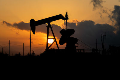 Silhouette man standing against orange sky