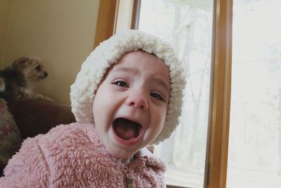 Portrait of cute baby girl shouting at home