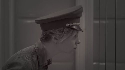 Side view of woman wearing cap looking away