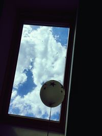 Low angle view of glass window against sky