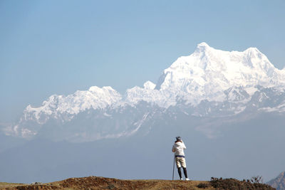 Full length of man walking on mountain against clear sky