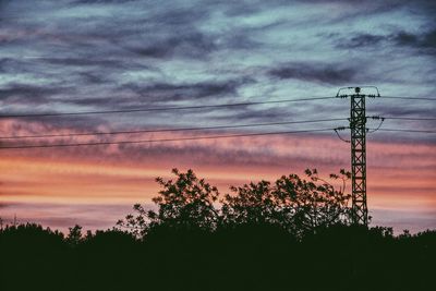 Low angle view of silhouette trees against cloudy sky