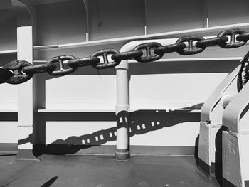 Closeup on metallic chains and white metallic structure of a ferryboat, sunlight and shadows, white 