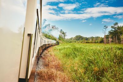 Train by railroad track against sky