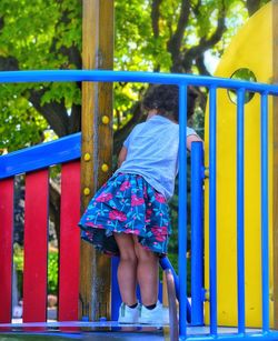 Rear view of girl playing on playground