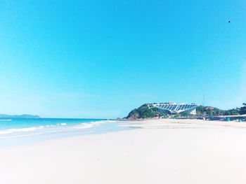 Scenic view of beach against clear blue sky