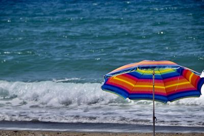 Deck chairs on beach against sea