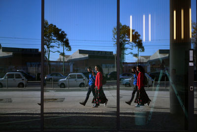 Reflection of couple walking on footpath