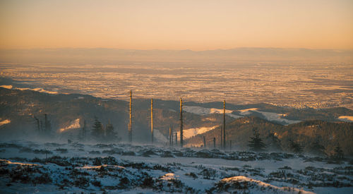Scenic view of snow covered mountains against sky during sunset