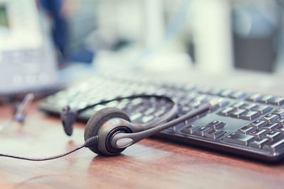 Close-up of headphones and keyboard on table