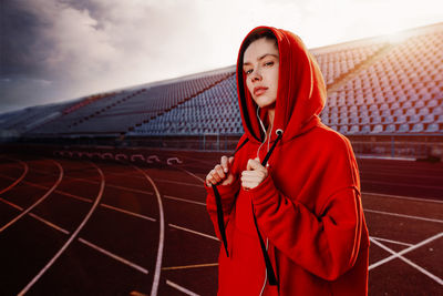 Portrait of young woman looking away against sky