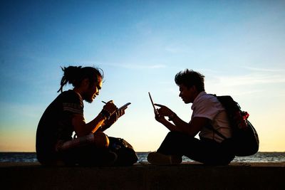 People playing guitar at music concert against sky at night