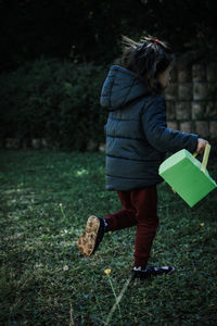 Rear view of woman walking on grass
