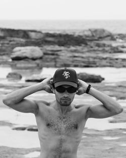 Portrait of shirtless man standing at beach