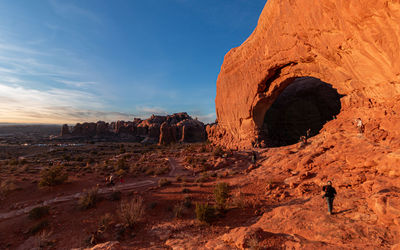 People gather and wait for scenic sunset in arches national park as the sandstone turns even redder