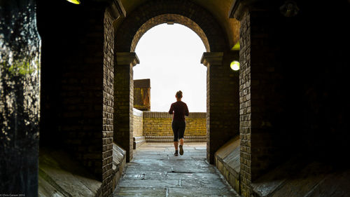 Rear view of man standing in corridor of historic building