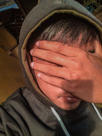 Close-up portrait of man covering face