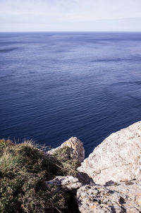 High angle view of rocks by sea against sky