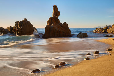 Rocks on beach against sky