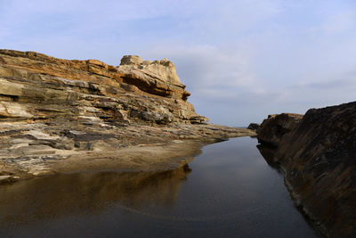 Scenic view of rocks on beach against sky