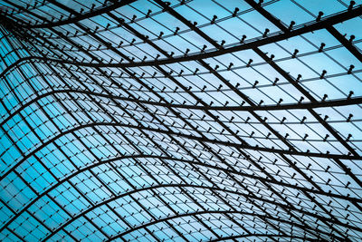 Low angle view of skylight through a metal grid pattern
