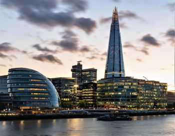 View of buildings at waterfront against cloudy sky