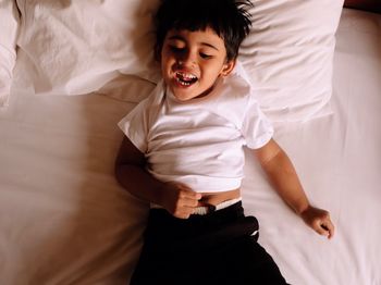 High angle view of cute boy on bed