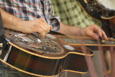 Close-up of man playing guitar